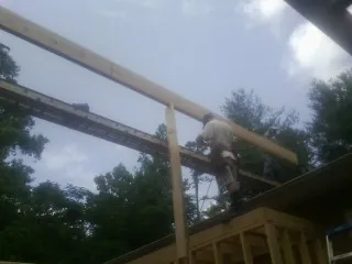 Carpenter setting a ridge beam over a new addition frame — Ice Dam Removal by Roofing Brothers in Bighorn