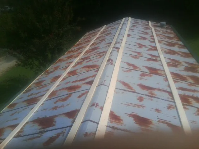 Rusted metal roof panels with new wood purlins before replacement — Storm Damage Roof Repair in Bighorn by Roofing Brothers