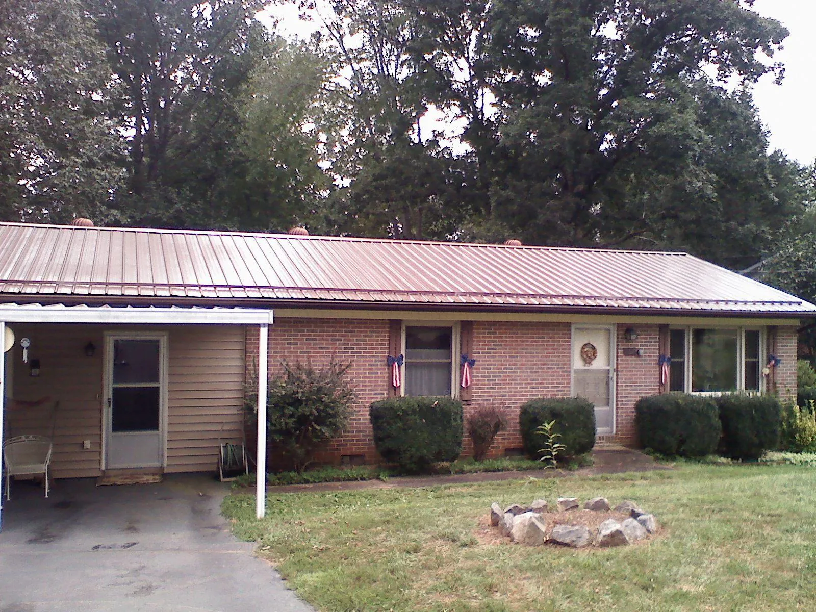 Bronze metal roof and carport on a brick ranch home — Roof Repair work by our crew in Bighorn
