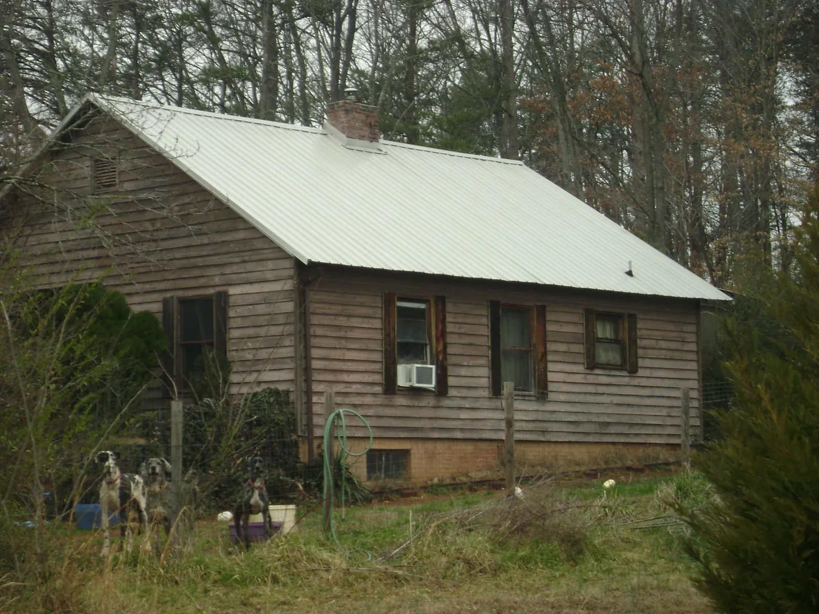 White metal roof on an old wood sided farmhouse, from a Metal Roof Installation job in Bighorn